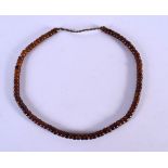 AN EARLY 20TH CENTURY MIDDLE EASTERN CARVED AMBER PRAYER BEAD TYPE NECKLACE comprising of many beads