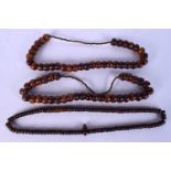 THREE EARLY 20TH CENTURY MIDDLE EASTERN AMBER PRAYER BEAD NECKLACES. 526 grams. Largest 60 cm long.