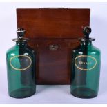 A LATE GEORGE III MAHOGANY CASED TRAVELLING DECANTER SET with green glass bottles. 25 cm x 18 cm.
