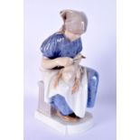 A ROYAL COPENHAGEN FIGURE OF A SEATED FEMALE modelled holding a duck. 23 cm high.