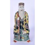 A 19TH CENTURY CHINESE FAMILLE JAUNE PORCELAIN FIGURE OF AN IMMORTAL Qing. 21 cm high.