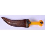 A 19TH CENTURY MIDDLE EASTERN OMANI CARVED AMBER HANDLED JAMBIYA DAGGER with white metal mounts. 32