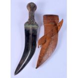 A 19TH CENTURY MIDDLE EASTERN OMANI CARVED RHINOCEROS HORN JAMBIYA DAGGER with leather scabbard. 34