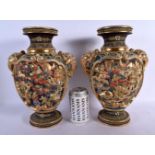 A PAIR OF JAPANESE TAISHO PERIOD SATSUMA TWIN HANDLED VASES decorated with figures. 32 cm x 18 cm.