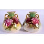 A PAIR OF ROYAL WORCESTER TWIN HANDLED PORCELAIN VASES painted with roses. 9 cm x 6 cm.