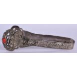 A PAIR OF EARLY 20TH CENTURY TIBETAN WHITE METAL TONGS inset with coral type stones. 15 cm long.