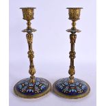 A PAIR OF 19TH CENTURY FRENCH CHAMPLEVE ENAMEL CANDLESTICKS decorated with foliage. 24 cm high.