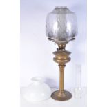 An brass oil lamp with an unusual mid glass iridescent lamp shade with an internal undulating patt