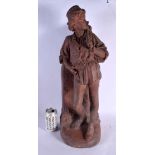 A LARGE 19TH CENTURY EUROPEAN TERRACOTTA FIGURE OF A MALE modelled holding a sack. 62 cm high.