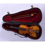 A CASED VINTAGE MINIATURE VIOLIN with bow. 16 cm long.