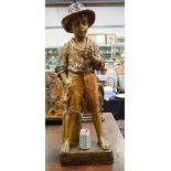 A LARGE ANTIQUE AUSTRIAN COLD PAINTED TERRACOTTA FIGURE OF A BOY modelled with one hand in his pocke