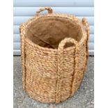 An antique hessian lined reed log basket 57 x53 cm