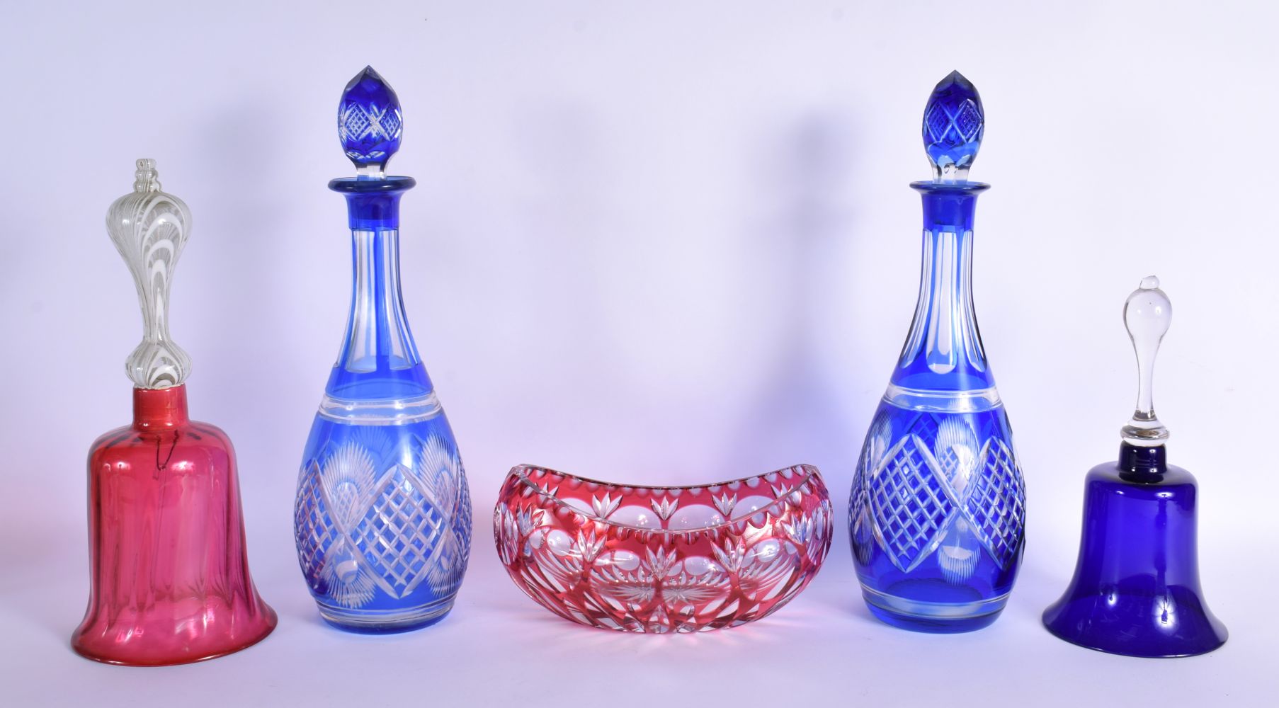 A PAIR OF BOHEMIAN BLUE FLASH DECANTERS with stoppers, together with a vase & bells. Largest 34 cm h