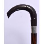 AN ANTIQUE SILVER MOUNTED CARVED RHINOCEROS HORN WALKING CANE. 86 cm long.