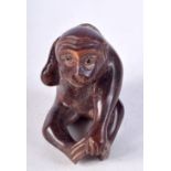 A JAPANESE CARVED WOOD NETSUKE CARVED AS A MONKEY HOLDING A FISH ON HIS BACK. 4.5cm x 4.1cm x 2.8cm