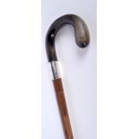 A bamboo walking cane with a silver collar and a Rhinoceros horn handle 92 cm.