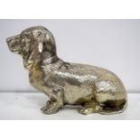 A white metal model of a Basset hound 10 x 16 cm.