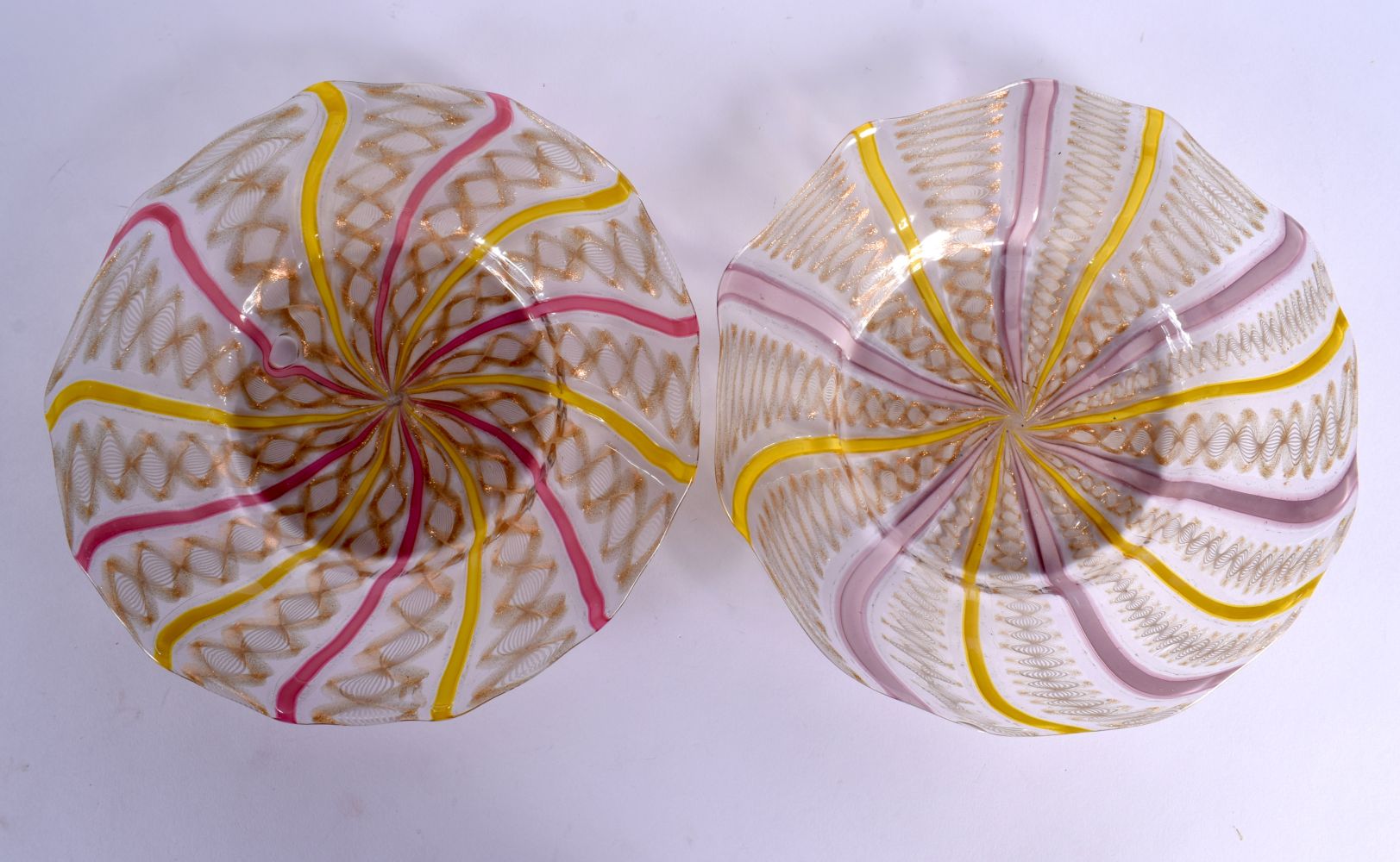 AN UNUSUAL PAIR OF EARLY 20TH CENTURY GLASS TWIST PLATES with pink swirling decoration. 19 cm wide.