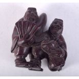 A JAPANESE CARVED WOOD NETSUKE CARVED AS MUSICIANS. 4cm x 3.6cm x 2.6cm, weight 12g