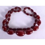 A CHERRY AMBER TYPE NECKLACE. Length 62cm, weight 49g, largest bead 20.9mm