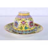 A small Chinese porcelain yellow ground tea bowl and stand decorated with foliage 5 x 7cm.