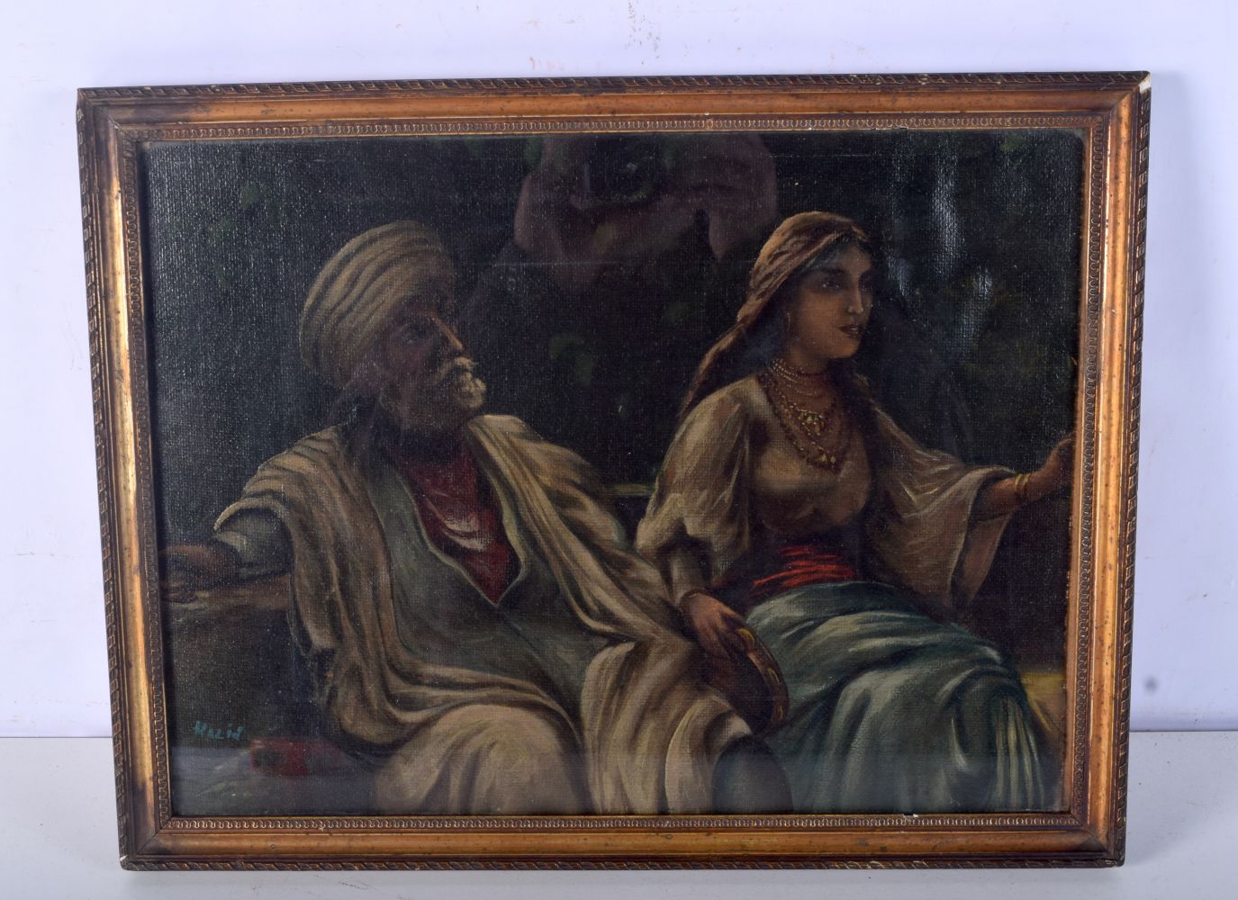 A framed oil on board of a middle Eastern couple signed Khaild 28 x 38cm.