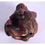 A CARVED JAPANESE NETSUKE OF A MONKEY HOLDING A FISH. 5.7cm x 4.4cm x 4.2cm