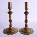 A PAIR OF 18TH CENTURY EUROPEAN BRASS SEAMED CANDLESTICKS upon petal bases. 21 cm high.