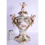 A LARGE EARLY 20TH CENTURY GERMAN PORCELAIN VASE AND COVER with figural cherub supports. 42 cm x 24