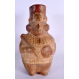 A SOUTH AMERICAN CARVED AND PAINTED TERRACOTTA FIGURE modelled holding a shield and weapon. 24 cm x
