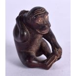 A CARVD WOOD FIGURE OF A SEATED MONKEY HOLDING A FISH ON ITS BACK. 4.5cm x 4cm x 2.8cm. Weight 17.4