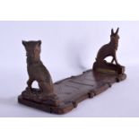 A 19TH CENTURY BAVARIAN BLACK FOREST CARVED WOOD SLIDING BOOK RACK formed with a fox and rabbit. 60