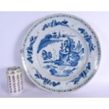 A LARGE 18TH CENTURY DELFT BLUE AND WHITE TIN GLAZED CHARGER painted with landscapes. 34 cm diameter