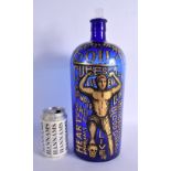 A LOVELY SEQUAHS OIL ADVERTISING BLUE GLASS BOTTLE modelled with a wrestler upon a skull. 37 cm high