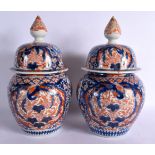 A PAIR OF 19TH CENTURY JAPANESE MEIJI PERIOD IMARI VASES AND COVERS painted with foliage. 30 cm x 15