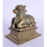 AN 18TH/19TH CENTURY INDIAN BRONZE FIGURE OF A SEATED BULL modelled upon a rectangular base. 8.5 cm