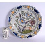 A LARGE 18TH DELFT FAIENCE CIRCULAR TIN GLAZED CHARGER painted with flowers. 31 cm diameter.