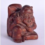 A JAPANESE CARVED WOOD PEN HOLDER IN THE FORM OF A SEATED MALE WITH A CARP ON HIS BACK. 5.8cm x 4.3