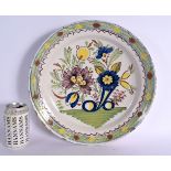 A LARGE 18TH DELFT FAIENCE CIRCULAR TIN GLAZED CHARGER painted with flowers. 31 cm diameter.