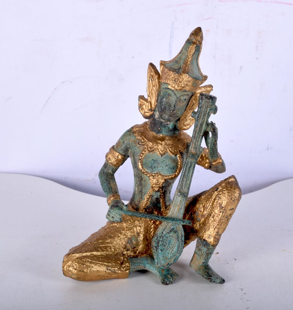 A small South East Asian bronze musician with gilt decoration. 14cm.