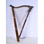 An unusual wooden and brass hat rack in the form of a harp. 61 x 38cm.