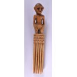 A RARE 19TH CENTURY AFRICAN CARVED BONE TRIBAL COMB formed with a standing figure.18 cm long.