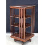 A Mid century wooden revolving book case on castors 115 x 54 cm.