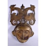A RARE 19TH CENTURY MIDDLE EASTERN INDIAN BRONZE MASK PLAQUE surmounted with birds. 34 cm x 20 cm.