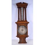 A large wooden aneroid barometer and thermometer. 93 x 31cm.