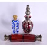 A VICTORIAN RUBY DOUBLE ENDED SILVER SCENT BOTTLE together with two others. Largest 14 cm long. (3)