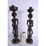 A PAIR OF EARLY 20TH CENTURY YAO TRIBE FIGURAL CANDLESTICKS modelled as two females. 41 cm high.
