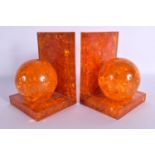 A RARE PAIR OF 1950S CRUSHED AMBER SPHERICAL BALL BOOK ENDS. 14 cm x 9 cm.