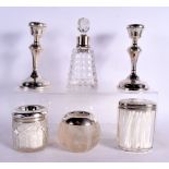 THREE ANTIQUE SILVER TOPPED JARS together with a silver mounted scent bottle & a pair of silver cand