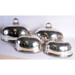 A SET OF FOUR ANTIQUE SILVER PLATED DOMED MEAT DISH COVERS. Largest 50 cm x 24 cm. (4)